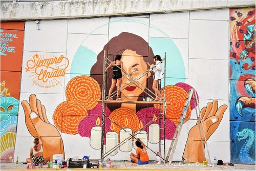 Figure 2. Las RestaurAmoras paint their largest and most physically challenging mural, of feminicide victim Steysi Burgos.