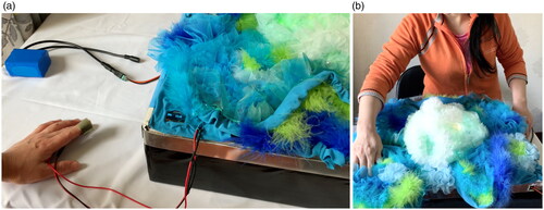 Figure 4. The exhibition. (a) The pulse sensor connected to the participant’s finger; (b) one participant interacting with Coral Morph.
