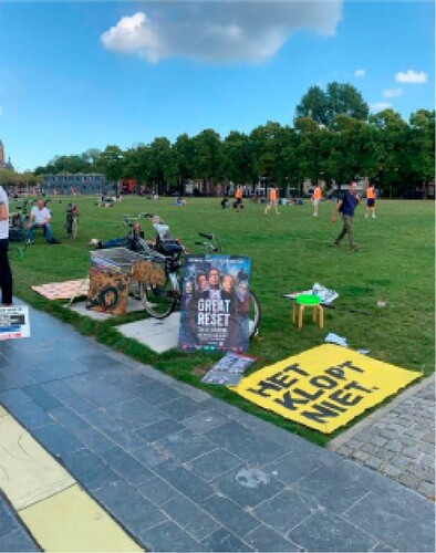 Figure 1. The attributes of a small gathering at the Museum square in Amsterdam, including a banner with the text ‘this isn't right’ and a ‘movie poster’ featuring George Soros, Dutch Prime Minister Mark Rutte, Klaus Schwab, Dutch Minister of Finance Sigrid Kaag and Bill Gates under the title: The Great Reset. Photographed by first author on 11 September 2022.