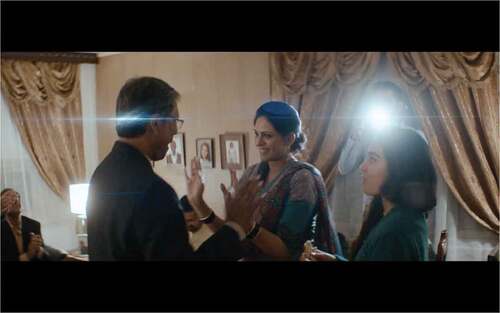 Figure 1. Mirza in What Will People Say (Haq, Citation2017) makes Najma dance in front of the party guests, while their son Asif is snapping pictures of them. Screenshot reproduced with the permission of Mer film.