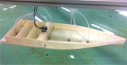 Figure 3. The model hull equipped with eight pressure sensors and a 6DOF motion sensor floating in the coastal wave basin.