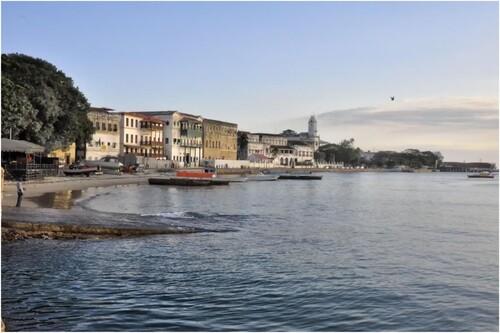 Figure 2. Zanzibar Stone Town waterfront in 2013. Of the buildings and sites visible in this image, several have been part of major restoration projects including Forodhani Gardens, the House of Wonders and the Palace Museum. The former Customs House in the British colonial era (the balconied building to the left) was restored and transformed into a hotel in 2014. Wikimedia Commons: https://en.wikipedia.org/wiki/File:Stone_Town_Waterfront,_Zanzibar_%2810163203685%29.jpg.