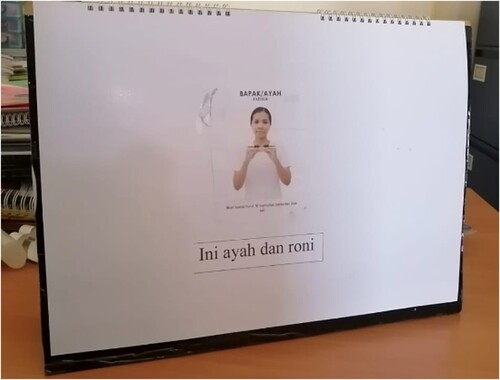 Figure 2. A keyword sign on the back of a Big Book story page. The text ‘ini ayah dan roni’ (this is Father and Roni) is supported with the Signalong Indonesia sign ‘Ayah’ (Father).