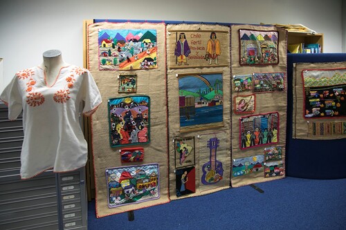 Figure 4. Arpilleras and embroidered blouse on display at the Crafting Resistance exhibition.