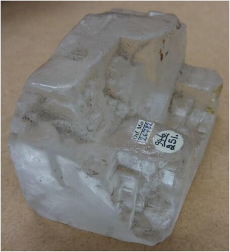 Figure 3. A specimen of halite (NaCl; OUNHM MIN.26782), featuring the characteristic rounding of corners and edges, and an opaque matte surface due to deliquescence. Image used with permission of Oxford University Natural History Museum.