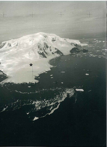 Figure 7. Peter I Øy from the north. Tvistein Pillars is off the north-western tip of the island. The location of the Ventimiglia shelter is marked with an asterisk. (Norwegian Polar Institute, aerial photo archive: Peter I Øy, 1987, image no. 430.)