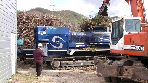 Figure 1. Tub grinder (DuraTech 3010T) and grapple excavator loader (Daewoo Solar 200W).