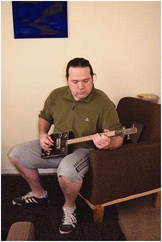 Figure 6 Rob Stephenson with one of his “pre-worn” three-string cigar box guitars.