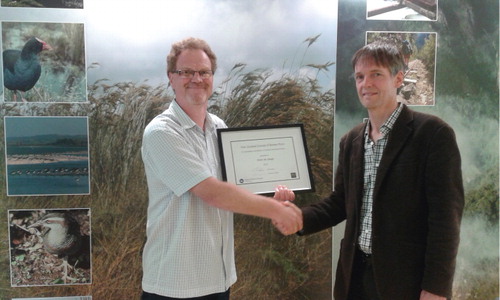 Figure 2 Presentation of the New Zealand Journal of Botany’s 2014 award to Dr Peter de Lange (left) by Dr Chris Lusk.
