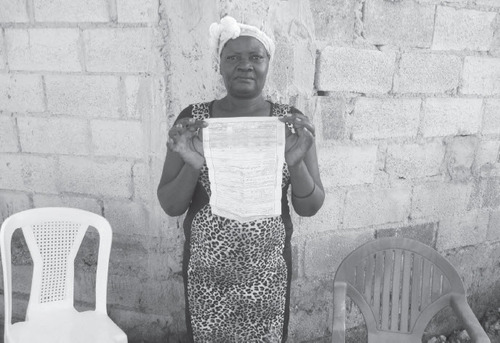 Marie, the sister of Robert Gabard, holds her brother’s death certificate. Gabard died on January 24, 2023 shortly before making it back to his home in the Dominican Republic after being deported to Haiti. (SIMÓN RODRÍGUEZ)