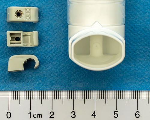 Figure 1 Plastic cable clip (left side: top, bottom, and side views) that accidentally got caught in the mouthpiece of the uncapped metered inhaler (right side) and was aspirated into the lung during inhalation.
