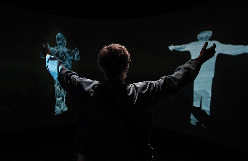 Figure 4. A participant moves their body to create a holographic portrait of the decision they make as the Child of Now. I-ME says, ‘The plains are flooding with salt water, becoming a mighty bay. Change can come dangerously quickly and life must find a way to adapt. Time to act. You must choose. Perform the gesture to make a decision’.