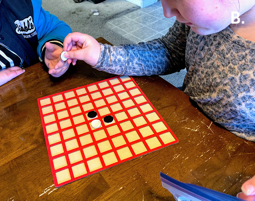 Figure 9B (B) Two teen girls with low vision play a later version of the game that incorporates 3-D–printed game pieces and a laser-cut game board.