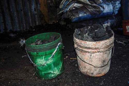 Figure 5. Charcoal buckets in Tandale, Dar Es Salaam, Tanzania illustrating differences in volume depending on the season. Left: green bucket filled during the rainy season vs. right, orange bucket filled during the dry season (photo by Amidu Mtalii, 16 February 2020).