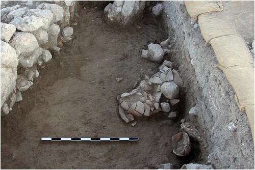 Figure 5 Restorable vessels on the floor of Level Q-9. On the left, the eastern wall of Schumacher’s Südliches Burgtor; looking north (courtesy of the Megiddo Expedition).