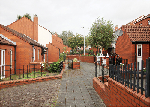 Figure 9. A supervised pedestrian passage through a 1980s west Belfast redevelopment. Here the “woonerf approach” that sought to break down large continuous streets into a series of smaller spaces has been somewhat reimagined to create a disjointed series of spaces that obscure the route through. Photograph: Donovan Wylie.