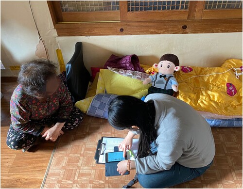 Figure 2 Sun-Oak (left) is looking at Hyodol while Yeon (right) is setting up the app (photograph by Heesun Shin).