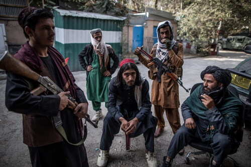 Taliban fighters stand guard outside a police station in Kabul, September 2021. Courtesy of dpa picture alliance / Alamy