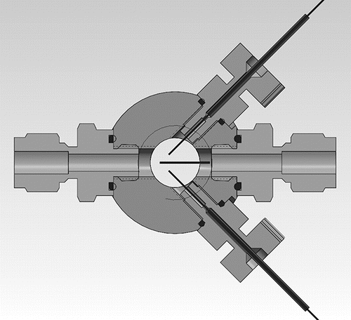 Figure 1. Scheme of the bipolar electrospray chamber with front and back windows; two gray connectors (PEEK) oriented at 90° bringing in one positive and one negative capillary emitter, and gas inlet (right) and outlet (left) connections. A stainless steel grid 30% transparent is symmetrically placed between the capillaries to decouple them electrostatically. An additional image is included in the SI.