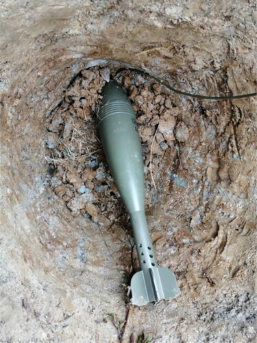 Figure 8. Placing a mortar bomb in the soil composition during experimental verification.