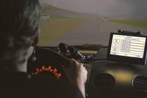 Figure 6 Touch screen mounted in simulator. Note also one of the two eye-tracking cameras, an IR illumination pod and the face video camera mounted on the dash.