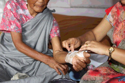 Figure 1. Healer tending to a fracture in an elderly woman.