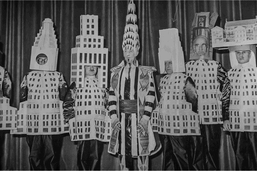 Manhattan’s architects, dressed as their own skyscrapers, perform ‘The Skyline of New York’ at the City’s Beaux Arts Ball in 1931. From left: (half covered) A. Stewart Walker as the Fuller Building, Leonard Schultze as the new Waldorf-Astoria, Ely Jacques Kahn as the Squibb Building, William Van Alen as the Chrysler Building, Ralph Walker as One Wall Street, D. E. Ward as the Metropolitan Tower and Joseph H. Freedlander as the Museum of the City of New York.Footnote8 Public domain (p. 759).