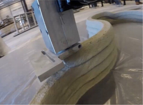 Figure 6. 3D concrete printer in operation. No-slump concrete leaves the nozzle as a relatively stiff continuous filament.