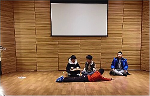Figure 4. Student on the left as a poet with Gu Qin (a Chinese instrument); student on the right as a guest; student in the middle as a small animal listening to the poet playing the Gu Qin; student lying down as grasses.