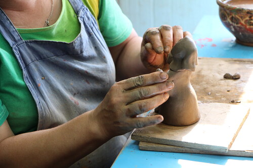 Figure 9. The hands of a female master from the “Belomorskie Uzory” company, modelling a female statuette of raw clay. Photo by V. Kobyshcha.