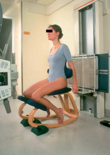 Figure 1:4C RSA in sitting position on a chair with standardized lowering of the knees allowing free passage of the x-rays above the femoral shafts to the lumbosacral spine. (Reproduced with permission from Spine).