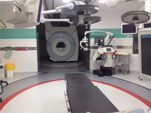 Figure 1 Dedicated interventional MRI setup with an MRI attached to the ceiling and parked in the back that is moved over to the surgery table when needed and subsequently moved back.