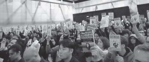 Attendees at the presentation of Agustín Laje’s latest book at the Buenos Aires International Book Fair hold up copies of Generación Idiota and other titles, May 3, 2023. (EZEQUIEL SAFERSTEIN)