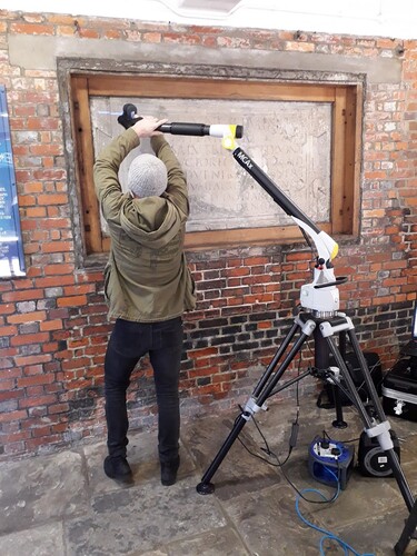 Figure 1. Scanning the Chichester tablet: The tablet is installed under an awning on the left-hand side of Chichester Town Hall. It is normally protected by a glass window, which was removed for the duration of the laser scanning.