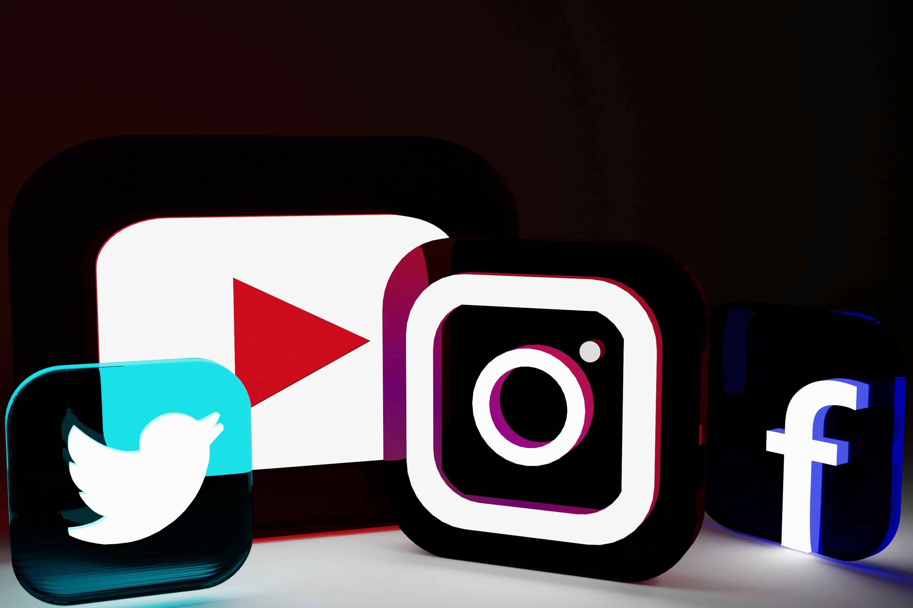 Logos of popular social media sites are displayed in translucent squares. From left to right, the logos are: Twitter, YouTube, Instagram, and Facebook