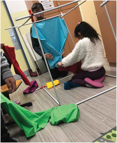 Figure 2. Creative engagements on the object with one design research attending to a specific child, some creating independently and the other design researcher quickly shifting between taking a picture and tentatively attending to the group.