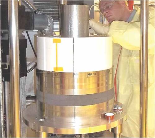 Fig. 4. The lower shielding and radial reflector being installed on the COMET platen, which consists of stacked 1-in.-thick rings of SS304 (shiny), B4C (dark gray), and BeO (white). Yellow tape holds TC wires.