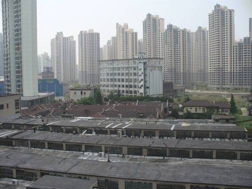 Figure 2 Old industrial spaces on Suzhou Creek: Surviving in a sea of high-rise condominiums. Source: Photo taken by Sheng Zhong on 23 May 2006.