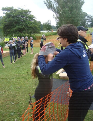 Figure 5. Lucy helping Natalie to put on her obligatory swimming cap before the start of a junior triathlon.Source: Authors.
