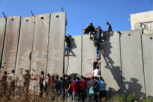 Figure 4: Palestinian youth climbing the wall (Photo: Huda Abuzaid).