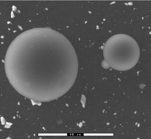 FIG. 1 Environmental scanning electron image of polystyrene spheres and metal particles produced from the sonic probe.