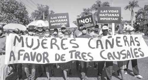 Demonstrators carry "Haitian lives matter!" placards during a demonstration against violence against women in Santo Domingo, November 25, 2021. Members of the Cane Workers' Union (UTC) hold a banner in favor of three proposed exceptions to the Dominican Republic's total abortion ban. (GUILLERMO CASADO)
