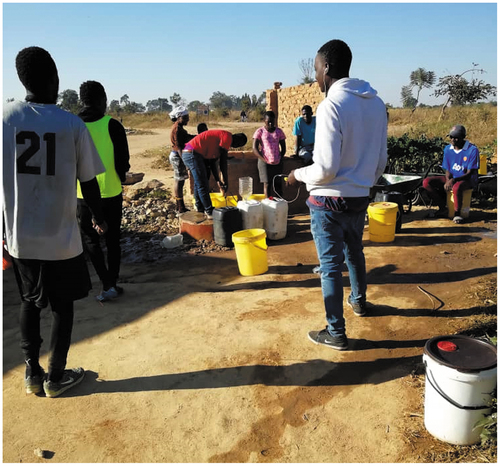 Figure 6. Young men assisting with collecting water at one of the communal boreholes in Hopley.