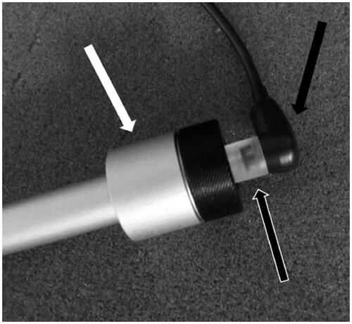 Figure 6. The ear simulator (711 coupler) (white arrow) with the SnapPROBE™ (black arrow) attached using the custom-made adaptor (black and white arrow).