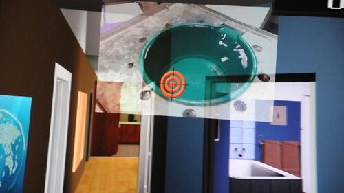 Figure 2 Viewpoint of the participant immersed in VR, with the live video feed from the cold pressor overlaid on the virtual apartment and the visual target.