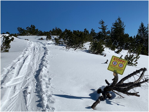 Figure 1. Signpost alerting skiers to not travers into a game conservation zone; tracks in the snow bear witness to non-compliance. Photo: Florian Bossert, Gebietsbetreuung Mangfallgebirge.