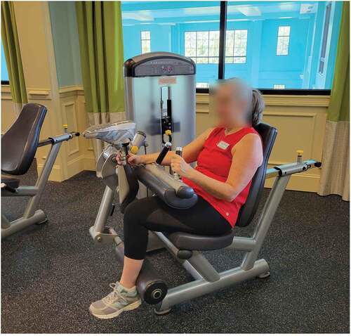 Figure 4. Kristin holding her prosthesis out of the way in order to keep it on while using a hamstring curl machine.