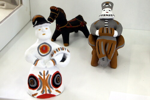 Figure 2. Traditional clay toys created by the craftswomen of the Center for Folk Crafts “Bereginya.” A bearded male figure sitting on a bench, a female figure with a basket, and a horse. Photo by V. Kobyshcha.