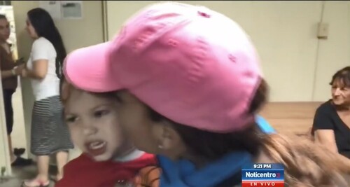 Figure 7. A reporter holds and kisses a crying toddler.