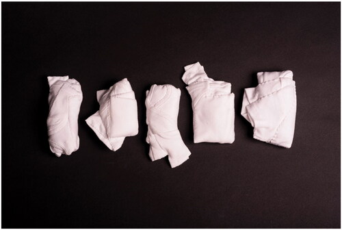 Figure 2 Baby’s vests wrapped, folded, and stitched to encase fabric bags of baby talc powder (maize starch). Photo credit: Oliver Cameron-Swan.